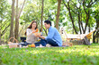 © Prathankarnpap - Happy couple enjoying picnic meal together while camping in a forest