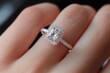 © inas - Elegant diamond engagement ring with cushion halo on female hand, close-up of luxury jewelry sparkle and detail
