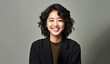 © Surachetsh - An Asian woman smiles softly in a cozy environment, offering a feeling of trust and approachability. Her casual look and natural presence suit personal branding.