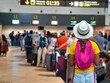 © Rafa Jodar - Tourist girl waiting in line to check in baggage at crowded airport counters.