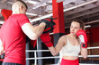 © New Africa - Woman in protective gloves having boxing practice with her coach at training center