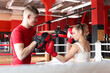 © New Africa - Woman in protective gloves having boxing practice with her coach at training center