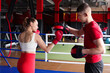 © New Africa - Woman in protective gloves having boxing practice with her coach at training center