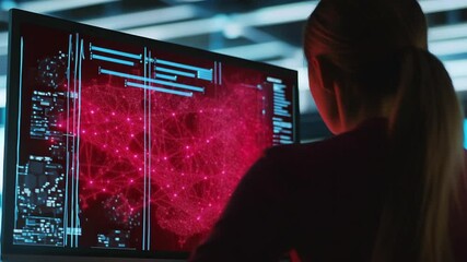 Female professional analyzing complex data network on computer screen in dark room