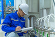 © reewungjunerr - Asian engineer working at Operating hall,Thailand people wear helmet  work,He worked with diligence and patience,she checked the valve regulator at the hydrogen tank.