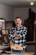 © Zoran Zeremski - Portait of smiling carpenter in his workshop looking at camera.