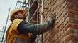 © Allie - Construction Worker Inspecting Brick Wall
