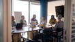 © CarlosBarquero - Professionals gather around a table in a contemporary office setting, actively participating in a productive meeting, fostering teamwork and innovation