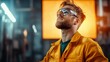 © Novcicrelax - A focused worker in a bright yellow uniform and safety goggles looks up, surrounded by machinery, embodying diligence and safety in an industrial environment full of energy.