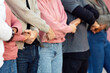 © Prostock-studio - International group of unrecognizable protestors standing together holding hands in protest picket on the street. Male and female activists protesting silently, expressing unity and strength, cropped