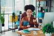 © deagreez - Confident young businesswoman in a modern office holding a tablet, engaged and smiling with professional workspace and natural light design