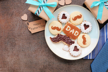 Leinwandbilder - Fathers Day corner border. Top down view on a dark stone background. Dessert plate of chocolate mustache, heart and dad cookies with ties, gifts and greeting card. Copy space.