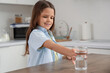 © Pixel-Shot - Cute girl taking glass of water from table in kitchen