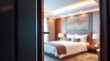 © BONDET LUCKY - Partial view through an open door into a serene and inviting hotel room, beckoning relaxation.