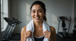 © Alina - Fit woman smiling with a towel in a gym background