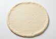 © Vooglo.com - Uncooked pizza dough round on white surface ready for toppings