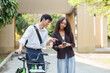 © itchaznong - Biking and Sustainability. A couple discussing eco-conscious choices while enjoying a bike ride.