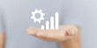 © AMK  - Hand holding graphic representation of growth with gear symbolizing progress, showcasing business development and innovation in a modern digital environment