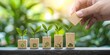 © kwanchaift - Hand Positioning Wooden Blocks with Business Icons Representing Growth and Success in a Contemporary Office Setting with Greenery in Background