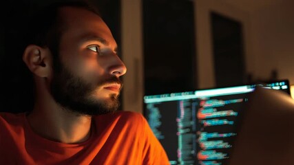 Man focused on computer screen at night.