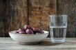 © IllustrateMuse - Bowl of dates with glass of water on rustic wooden table