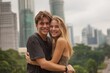 © Marcos Kulenkampff - A happy couple embraces in front of a city backdrop, expressing love and joy.