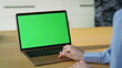 © stockbusters - Hands using touchpad chroma key laptop surfing online at home apartment closeup.