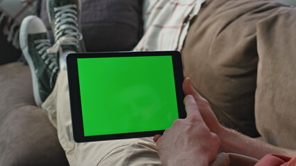 Wall Mural - Man shopping online mockup tablet at home sofa closeup. Unknown guy scrolling