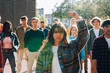 © Carlo Prearo - Young woman raising fist during protest march with diverse group of students