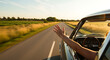 © Segati - Open Road Adventure: A spirited traveler stretches an arm out of a classic car on an open road, embodying the freedom and joy of a scenic drive, bathed in the golden sunlight.