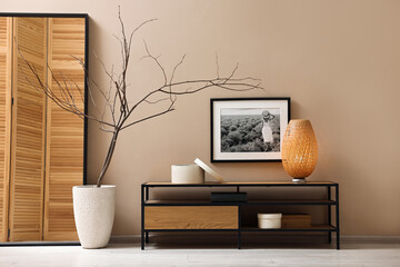 Poster - Console table with lamp and decor near dark beige wall in room. Interior design