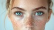 © Kusuma - Close-up of a woman's face, showcasing freckles and light eyes