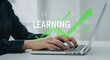© vision code - Person typing on a laptop with a green arrow and the word learning superimposed on the screen real estate business ,technology ,selling ,purchasing ,agreement ,$