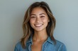© Vibu design  gallery - A young woman with long brown hair smiles warmly at the camera, wearing a denim shirt.
