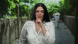 © Krakenimages.com - Woman gesturing silence while standing outdoors in a city street, embodying calm and peaceful ambiance amidst urban surroundings during daylight.
