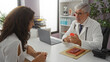 © Krakenimages.com - Doctor talking to patient in modern clinic office, discussing healthcare options with woman in a professional medical setting, featuring diverse elements of a hospital room.