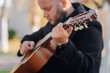 © Ljustina - Musician playing acoustic guitar outdoors in park
