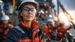 © Mrammon - A woman wearing a hard hat and safety glasses stands in front of a group of men