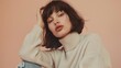 © Eireen - Elegant woman with short dark hair in cream turtleneck sweater on soft beige background