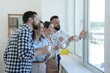 © New Africa - Colleagues looking out window during coffee break in office