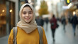 © Maksym - Cheerful Middle Eastern teenage girl in casual clothing and a light scarf stands with confidence on a modern city street, blurred background of cafÃ©s and pedestrians, stylish backp