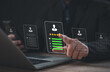 © Vatcharachai - Businessman using laptop and mobile with virtual interface showing user profile, five-star rating, and performance bars, representing digital evaluation and employee ranking system.