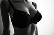 © Maryna - Silhouette of woman wearing black lingerie. Focus on bust area in dark, studio shot with a soft light, lingerie fashion, sensual. Intimate apparel, luxury garment for woman, sexy body shape.