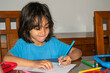 © Mandy - Young boy drawing with colored pencils on a sheet of paper at home