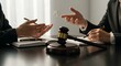 © avissarahmanita - Dark Wooden Gavel on Polished Table with White Notebook Pen and Gesturing Hands Isolated Against White Background Depicting Legal Discussion