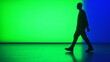 © aleks - Individual walking against a vivid backdrop of green and blue lights in a modern space