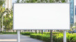© Thanakit  - Blank billboard stands prominently in green park area, surrounded by trees and urban scenery, inviting creativity