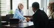 © peopleimages.com - Business, woman and handshake with couple in office for finance consultation, debt management and welcome. Financial advisor, mature person and shaking hands in meeting for insurance planning or help