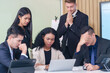 © Prapol Srinakara - frustrated multiracial business people seriously meeting in office room,bad condition business conference,problem,worry of results business crisis