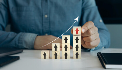 Leinwandbilder - Close up hands stacking arrow on wooden block for business growth and achievement success concept. Arrow up with graph of business analysis. Business development, financial plan and strategy.
